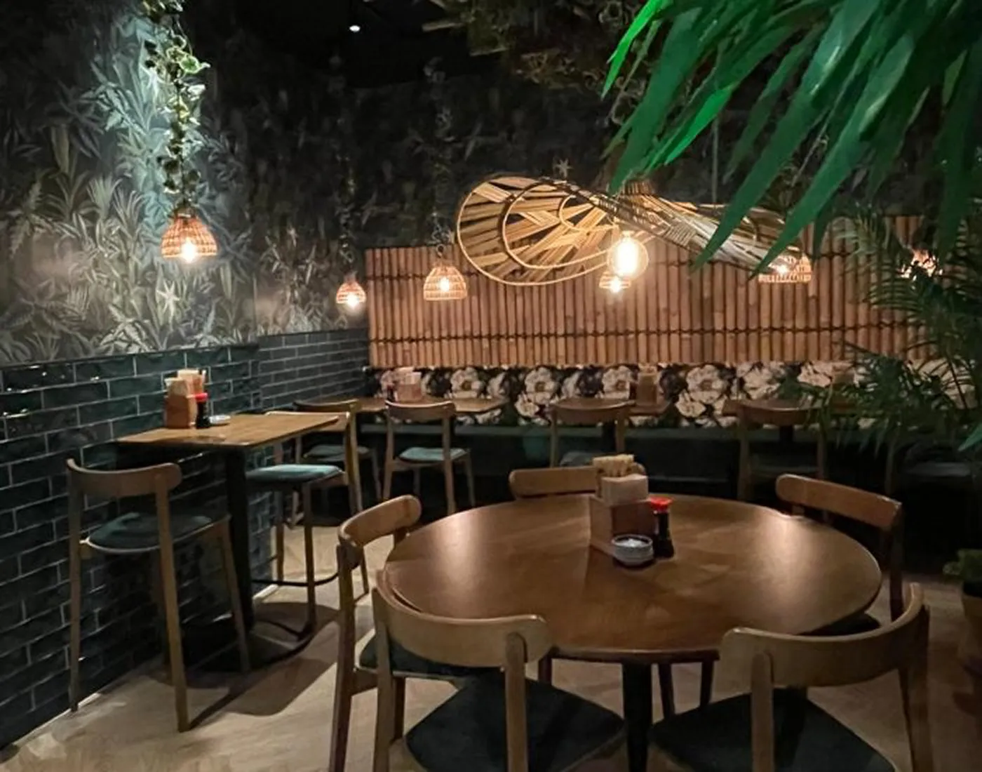 Restaurang Lulus matsal, med gröna kakelplattor, rottinglampor och runda träbord